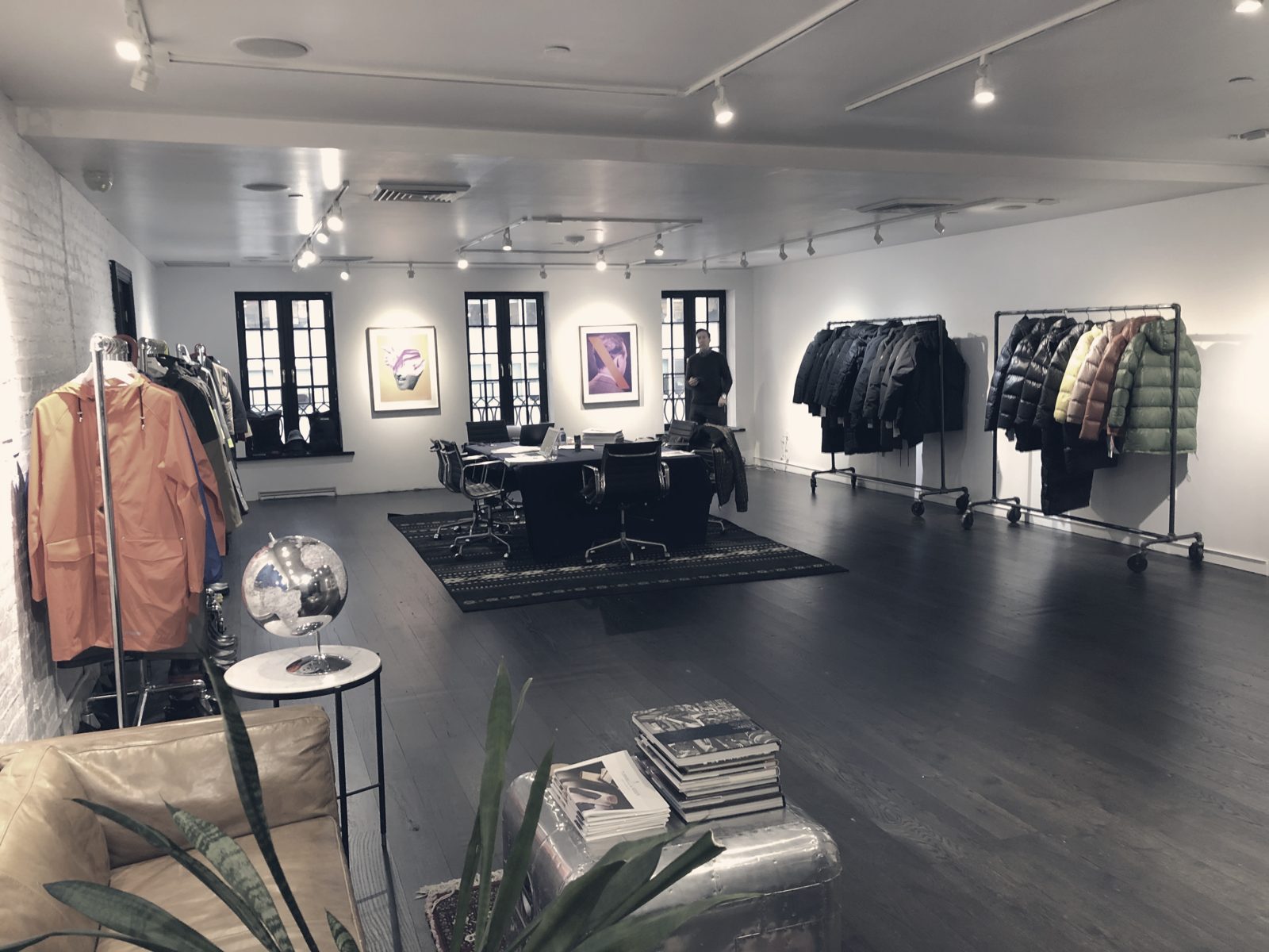 A wholesale showroom in New York: racks of outerwear, a meeting table and samples set for market week